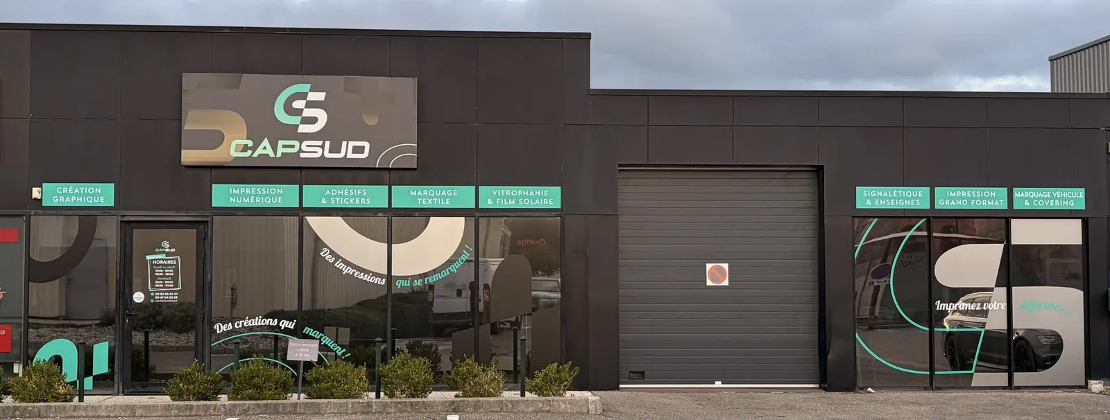 Façade actuelle de l'atelier : nouvelle enseigne Cap Sud, bandeaux turquoise des métiers et vitrines habillées