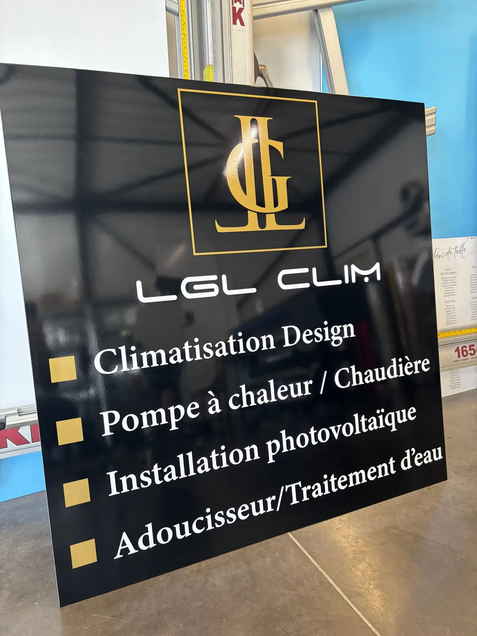 Panneau de sponsoring noir et doré listant des services