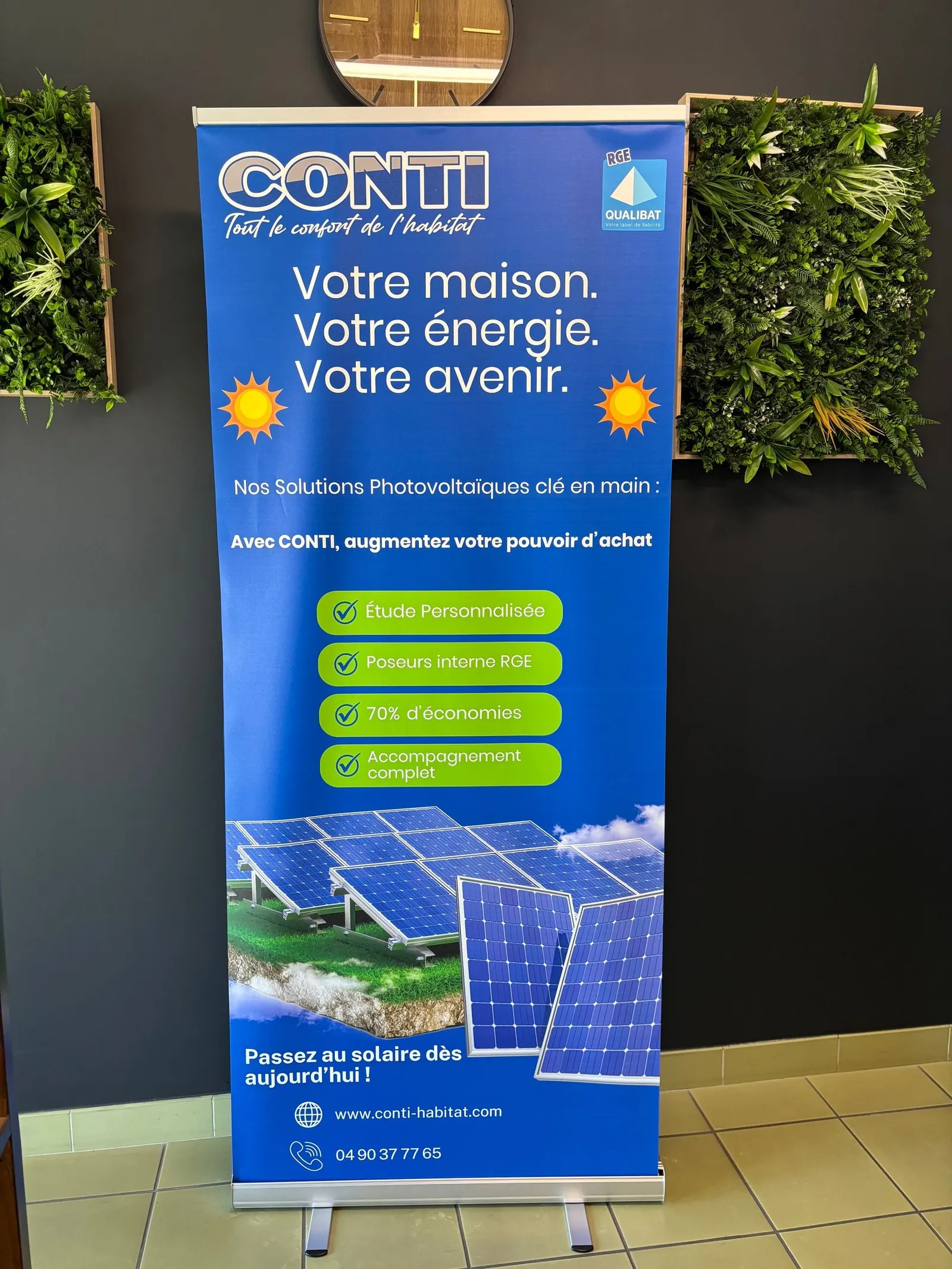 Roll-up bleu devant un mur végétal