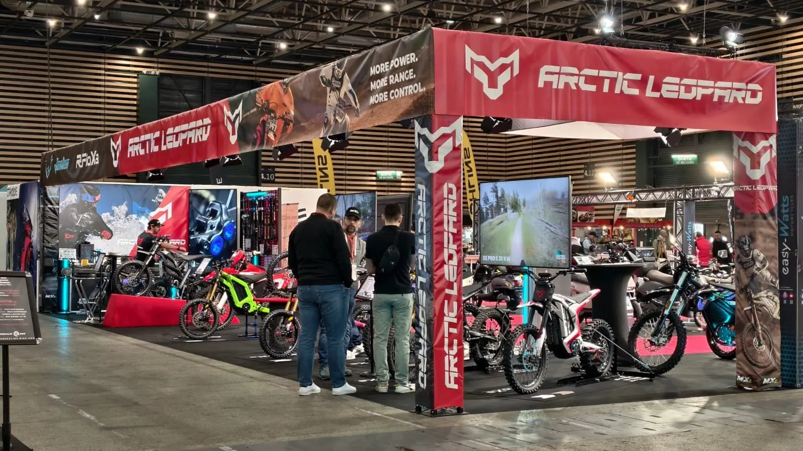 Stand de salon habillé de bâches rouges, avec motos exposées
