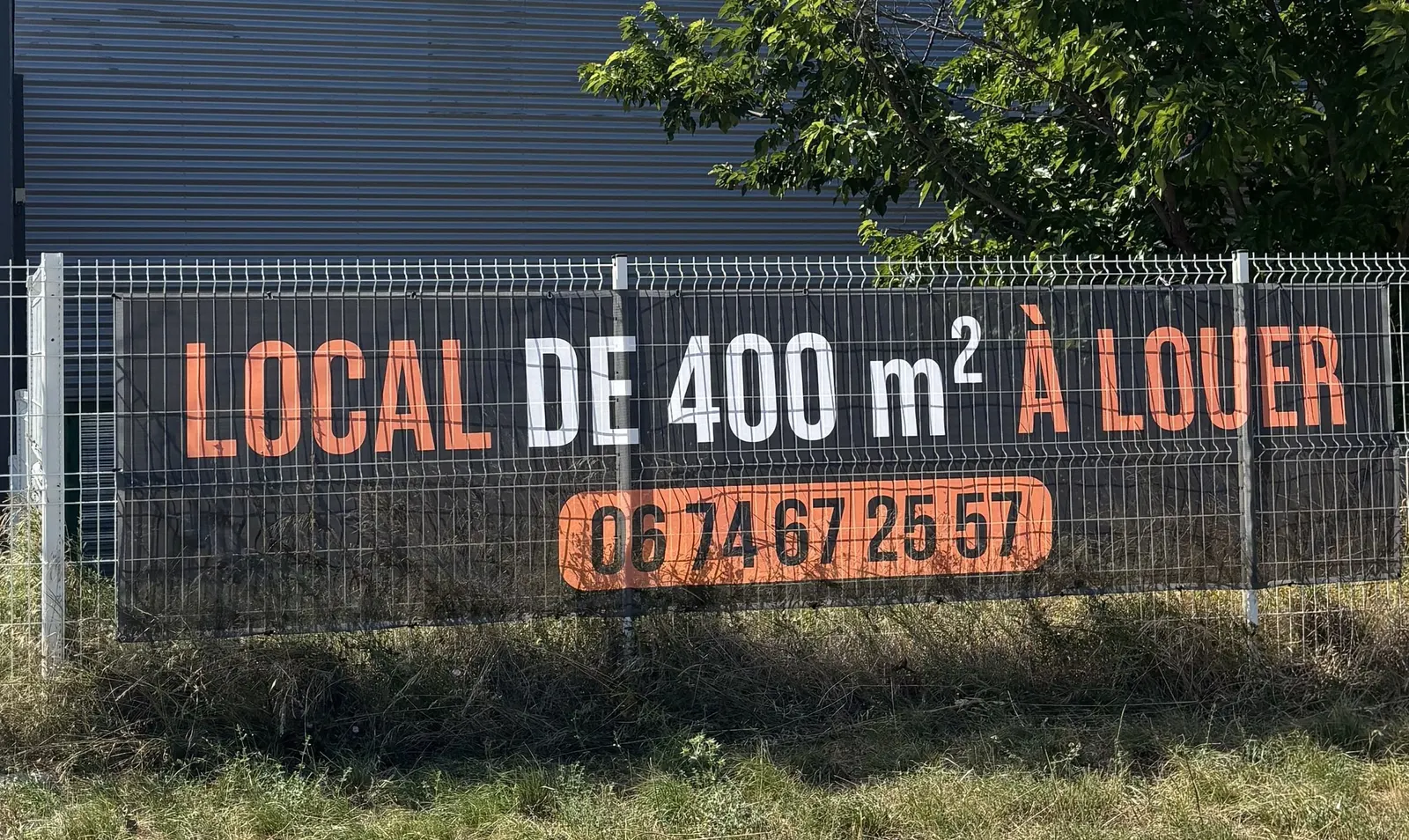 Bâche microperforée « local à louer » tendue sur une clôture