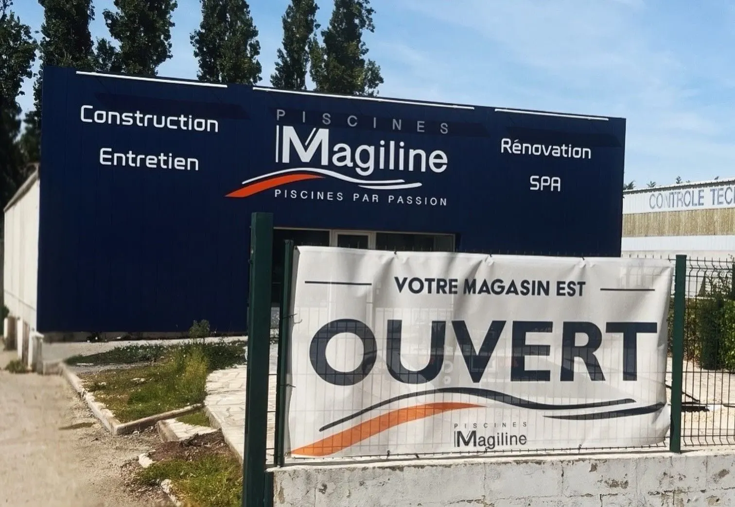 Bâche « votre magasin est ouvert » fixée sur une grille devant un magasin