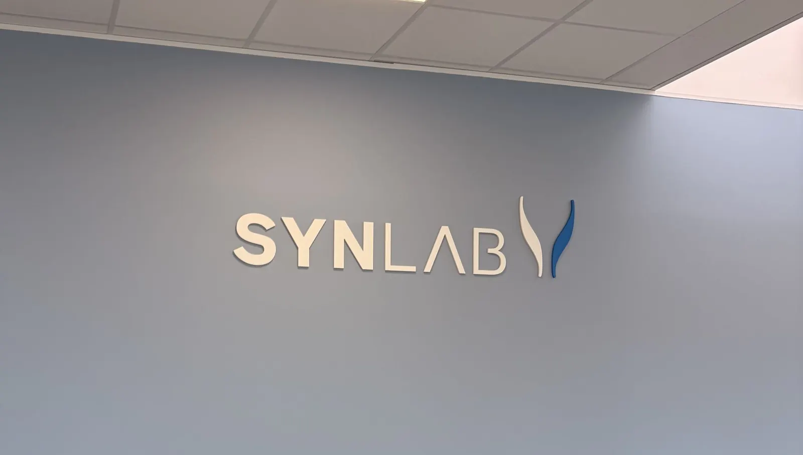 Logo en PVC découpé posé sur un mur gris