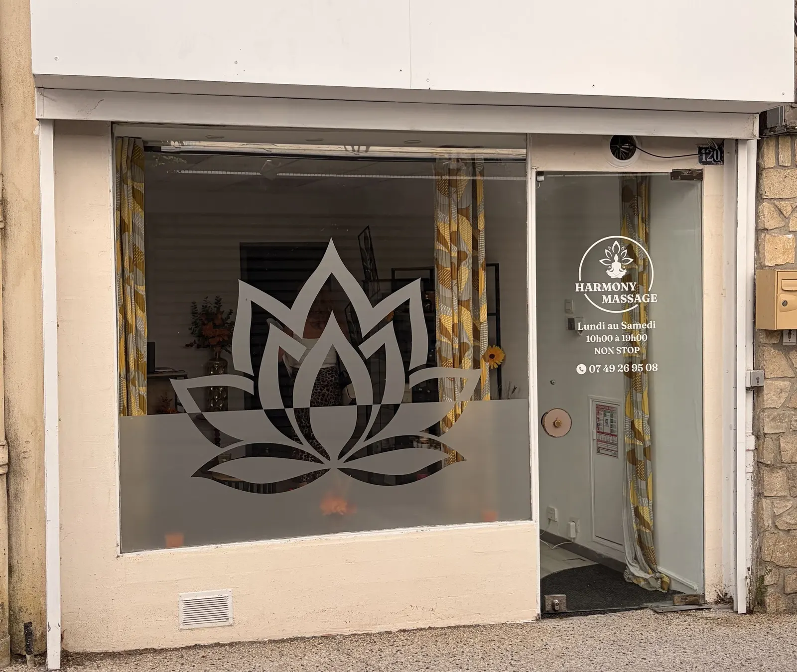 Vitrine avec motif de lotus en film dépoli et horaires sur la porte