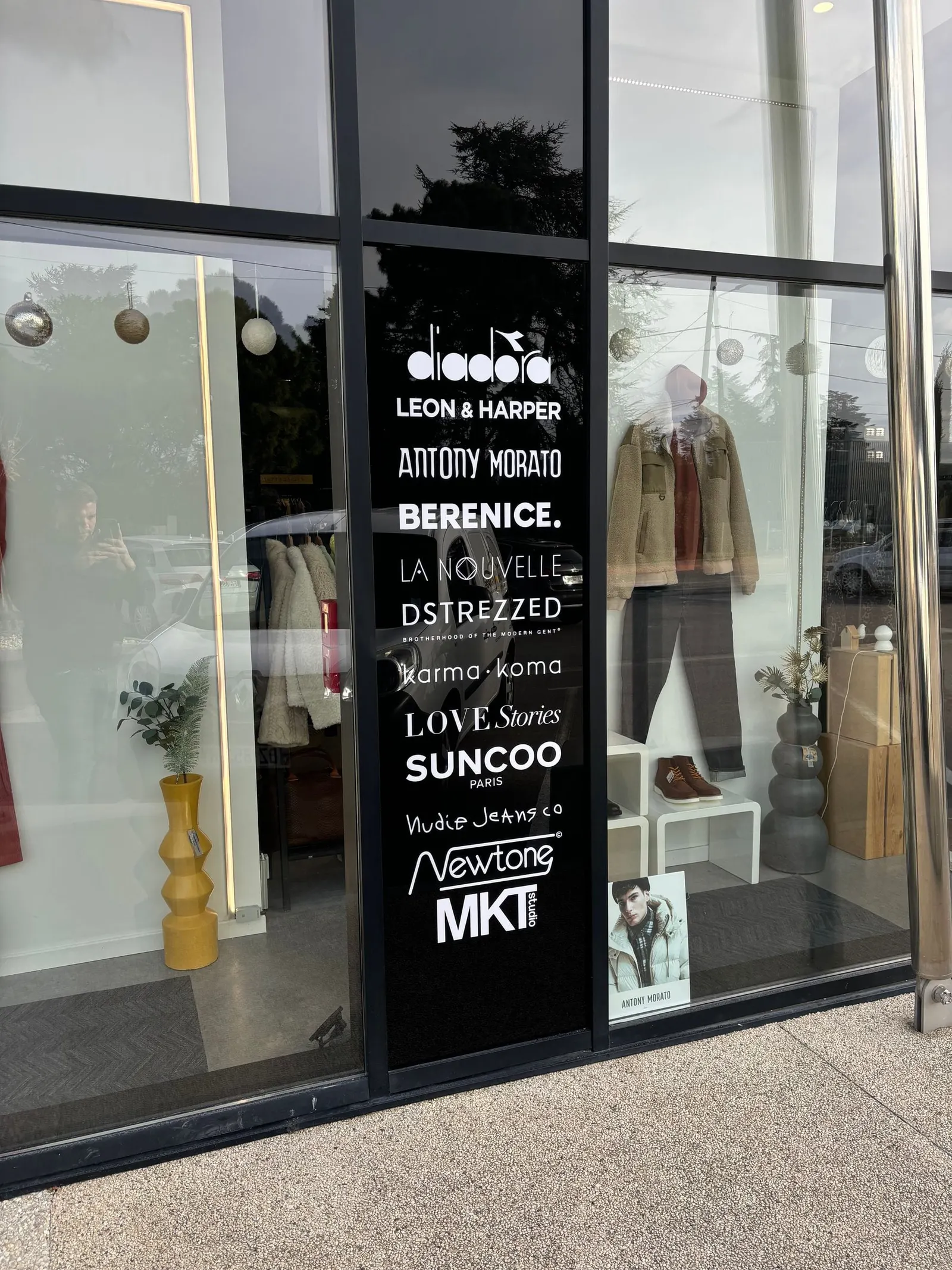 Vitrine de boutique avec liste de marques en lettrage blanc découpé