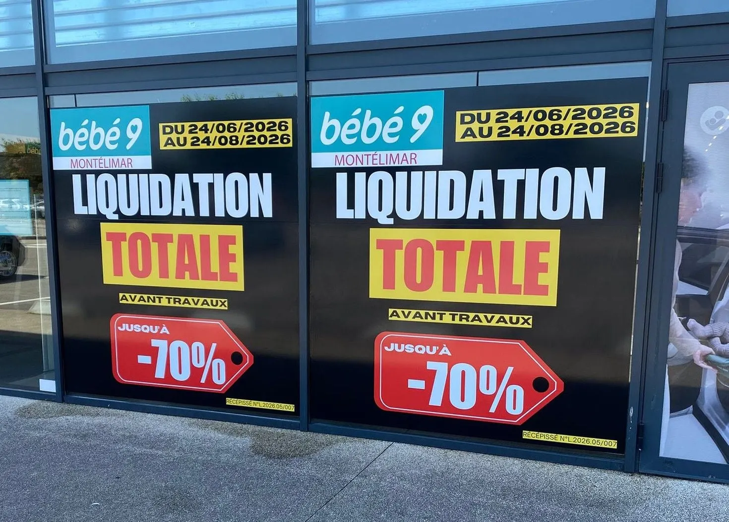 Vitrines couvertes d'affiches « liquidation totale » jaunes et rouges